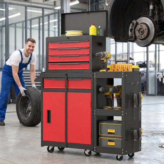 A mechanic rolls a tyre next to the red tool cabinet in a workshop