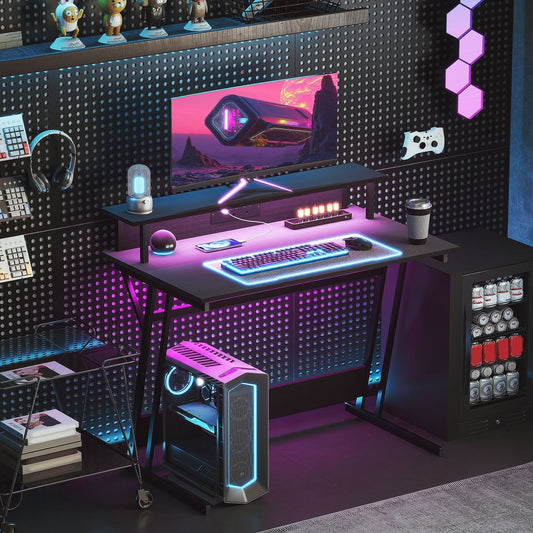 The gaming desk set up in a room with a computer, monitor and accessories