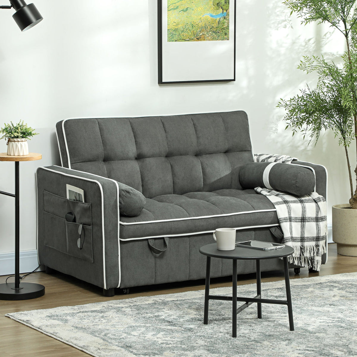 The sofa bed placed in a modern living room setting with a side table and a patterned rug