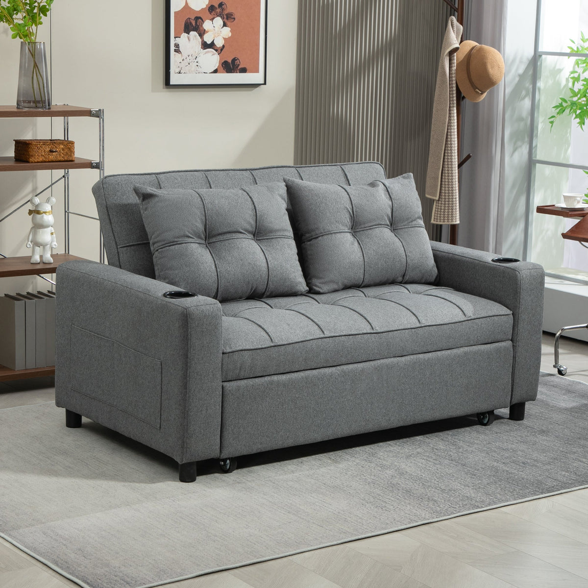 The two-seater sofa bed in a living room setting with shelves and a coat rack behind it