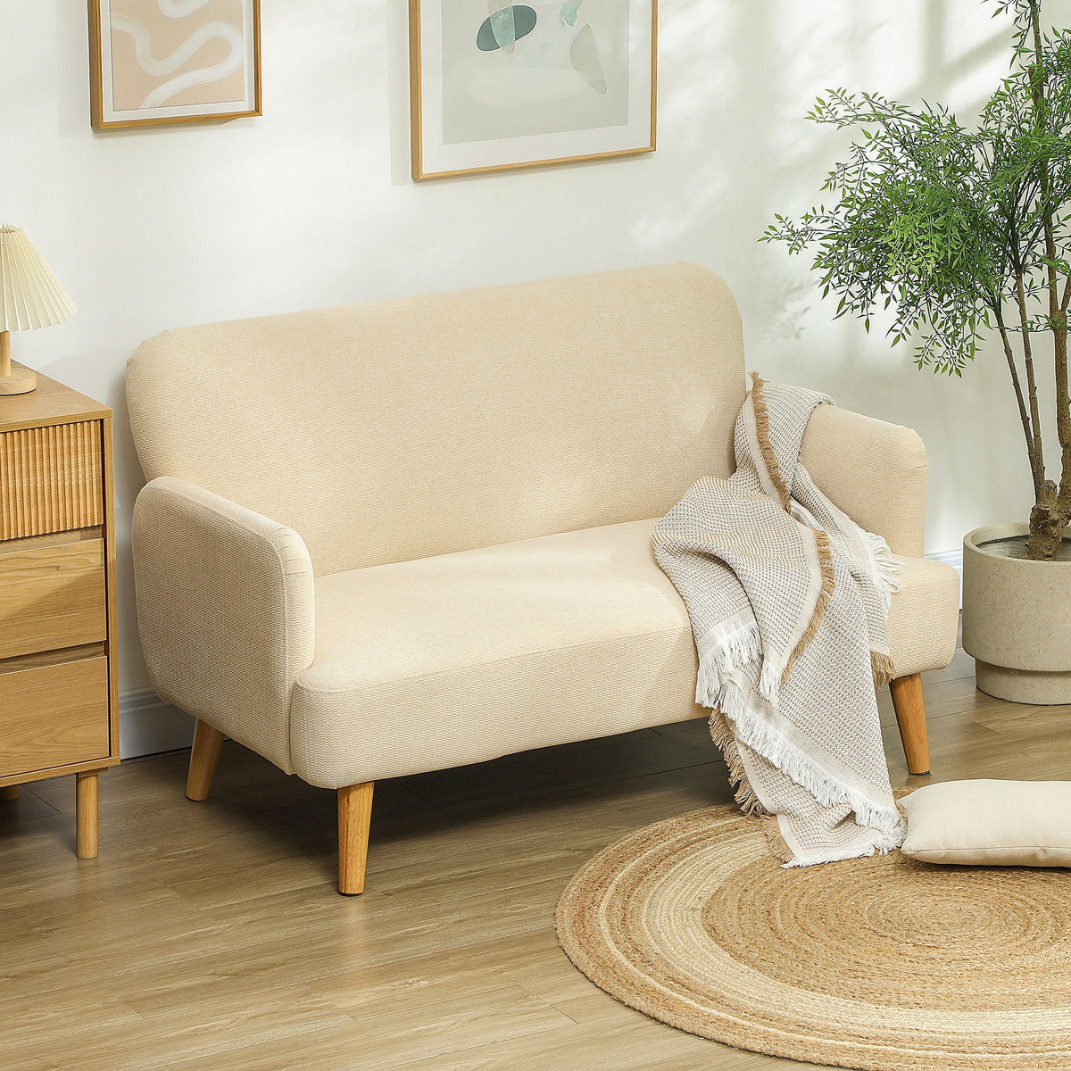 Cream white two seater sofa in a living room setting with a throw blanket