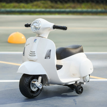 The white kids electric motorbike parked on a grey surface with a yellow ball in the background
