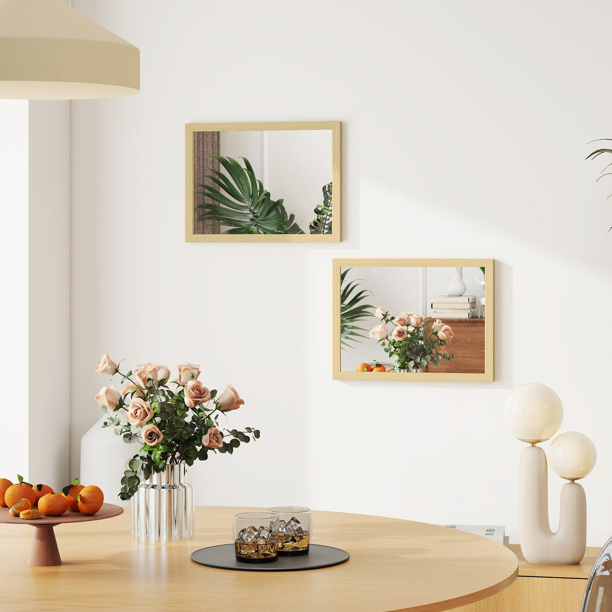 The wall mirrors hanging on a dining room wall reflecting a plant and flowers on the table