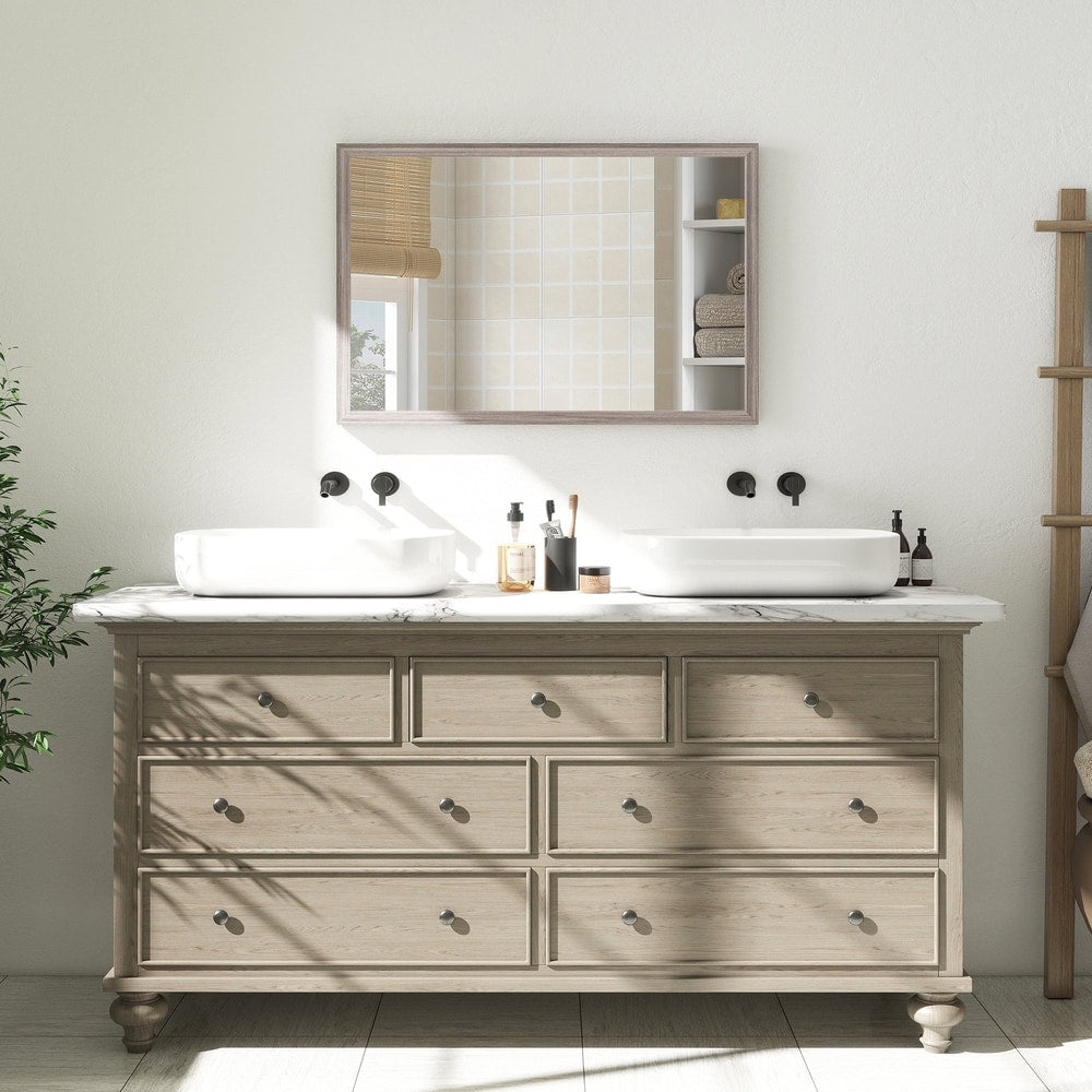 The wall mirror is shown above a wooden dresser with white sinks