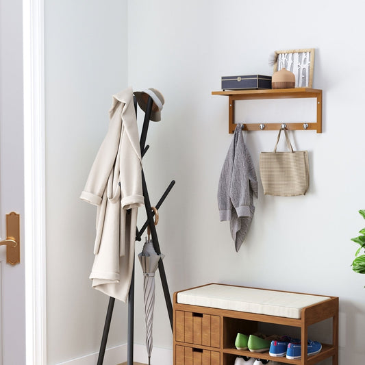 The coat rack mounted on a wall in a hallway with items hanging from the hooks and on the shelf