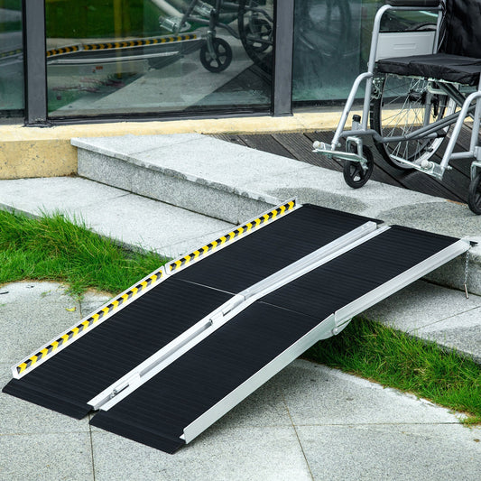 The folding ramp positioned against stone steps with a wheelchair waiting to go up
