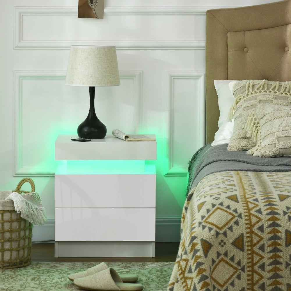 The white bedside table with LED light is shown in a bedroom setting next to a bed