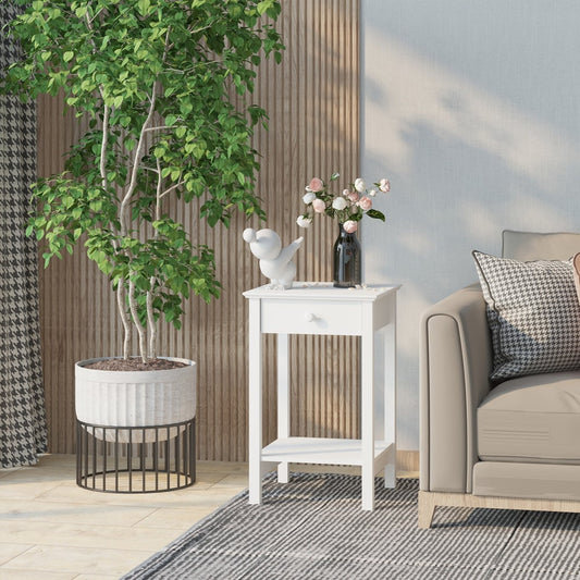 The white bedside table in a living room next to a sofa and a large plant