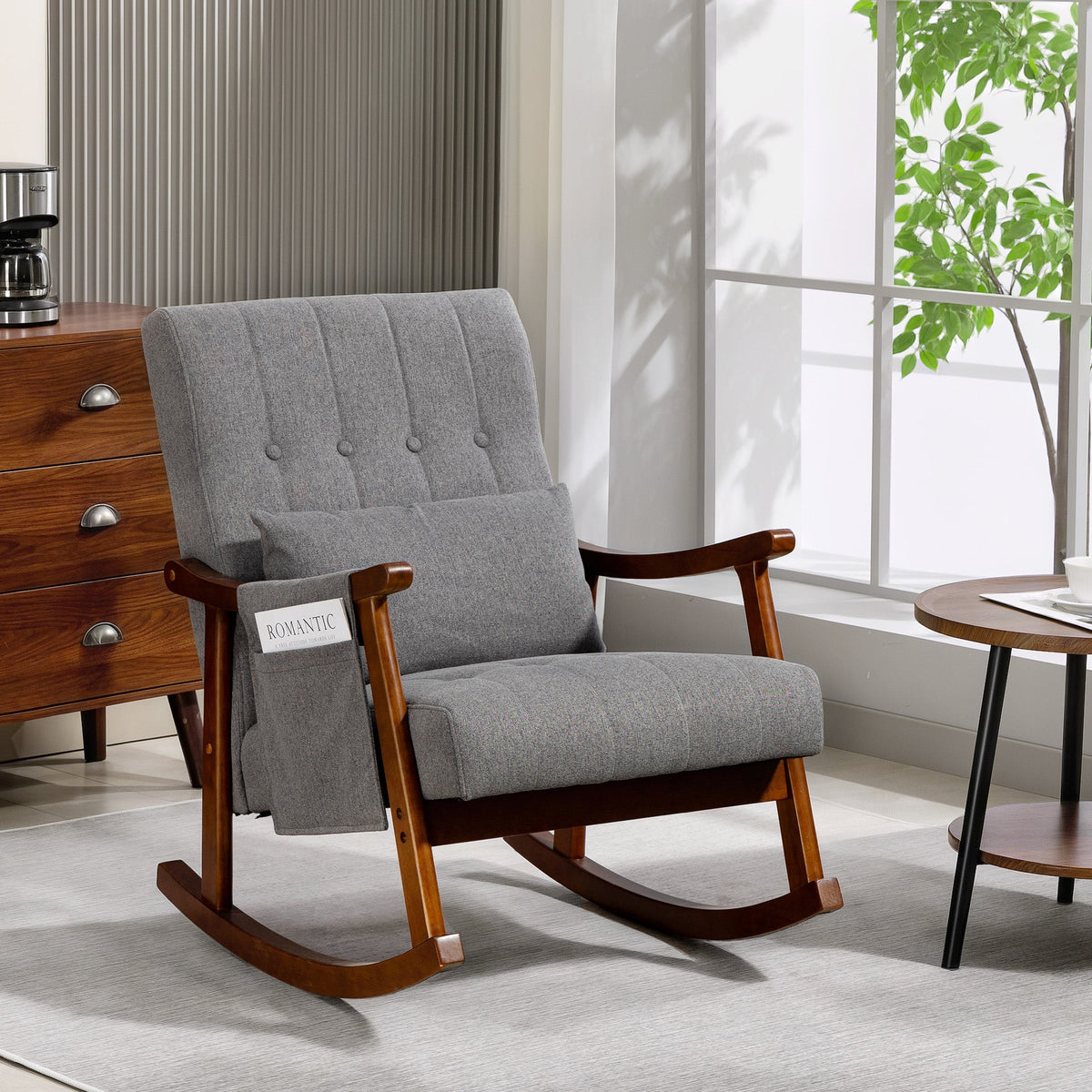The rocking armchair placed in a bright living room next to a wooden side table and chest of drawers