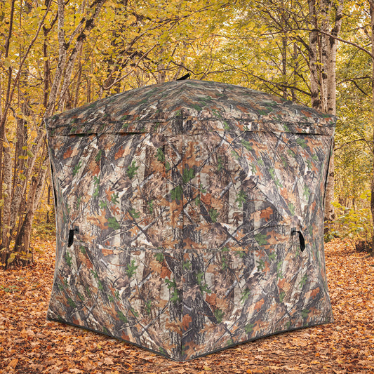 The pop-up tent positioned in a woodland area with autumn leaves on the ground