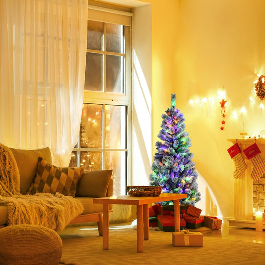 The artificial Christmas tree with lights on in a cosy living room at night