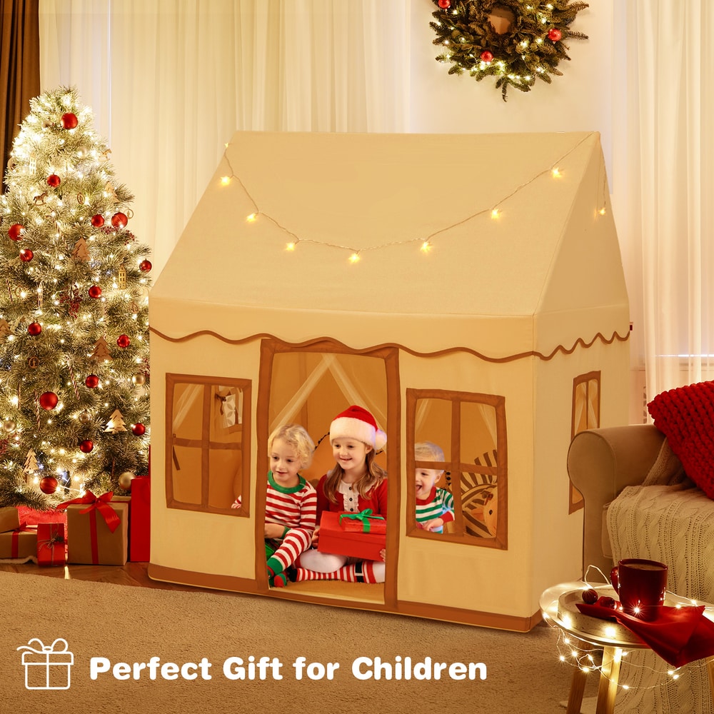 Children sitting inside the play tent with star lights, a festive Christmas tree nearby