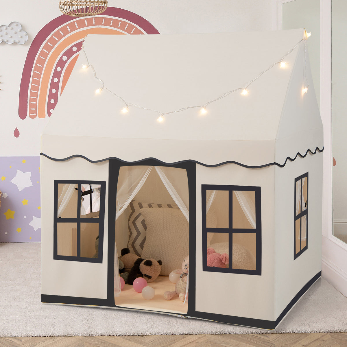 The beige playhouse with star lights draped across the roof and windows