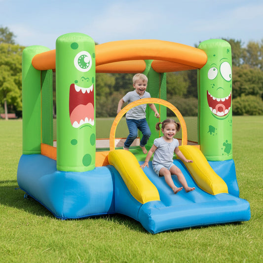 Kids bouncing and sliding on the monster themed bouncy castle in a garden setting
