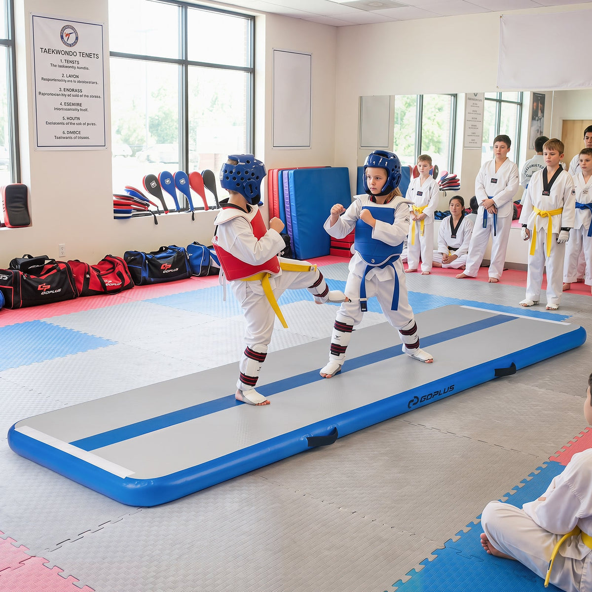 The gymnastic mat being used by two children in taekwondo gear for a training session