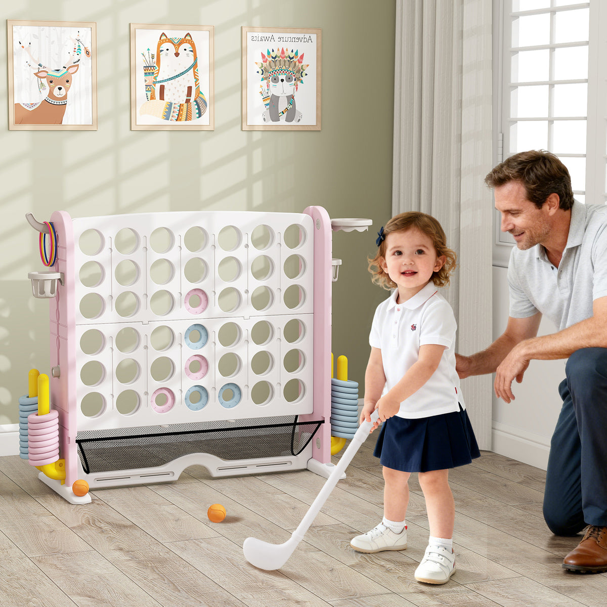 A father and daughter playing with the giant connect four game set indoors