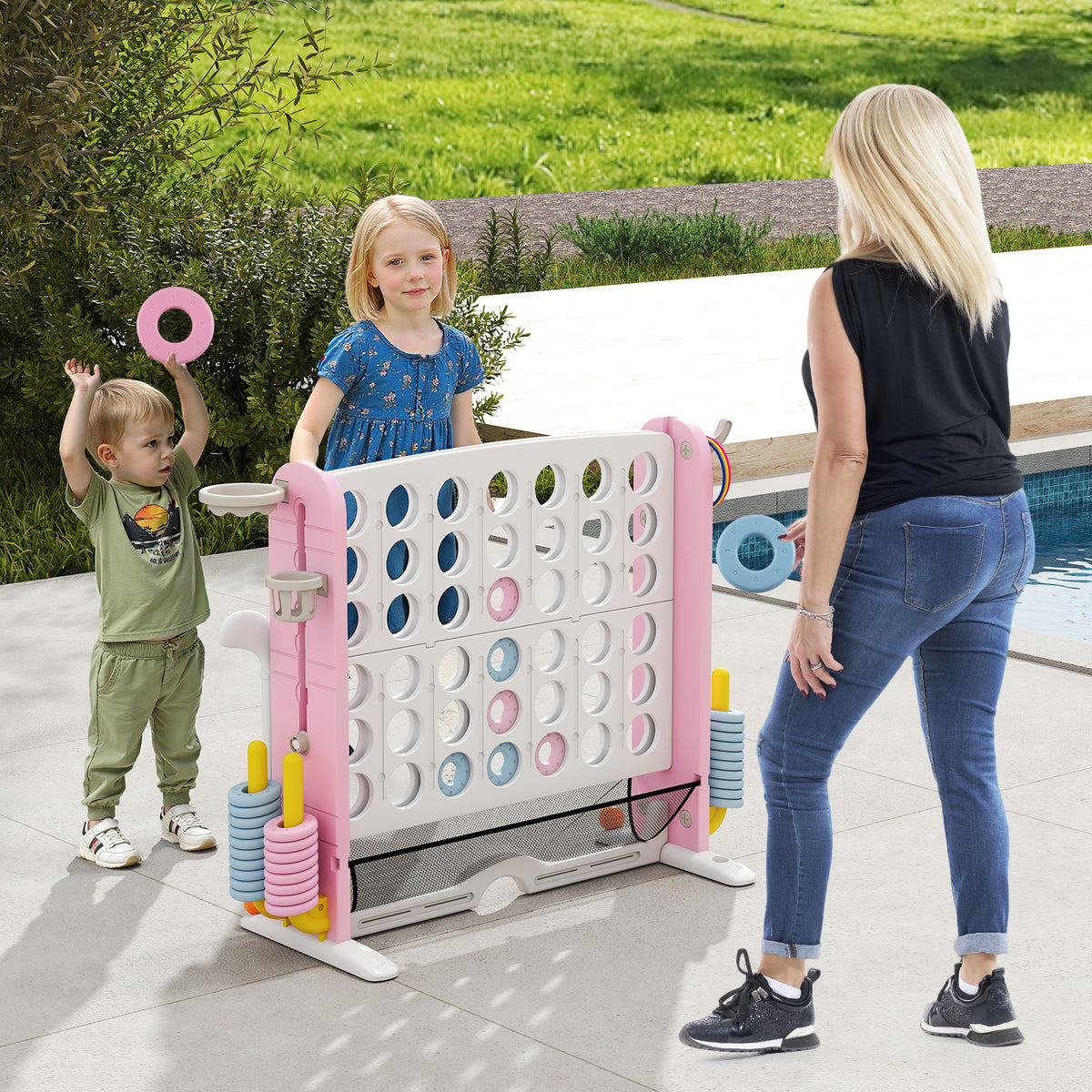 Children playing the large connect four game set on a patio by a swimming pool