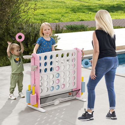 Children playing the large connect four game set on a patio by a swimming pool