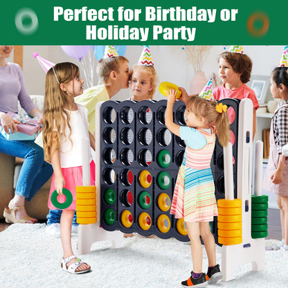Children playing the giant four-in-a-row lawn game at a party