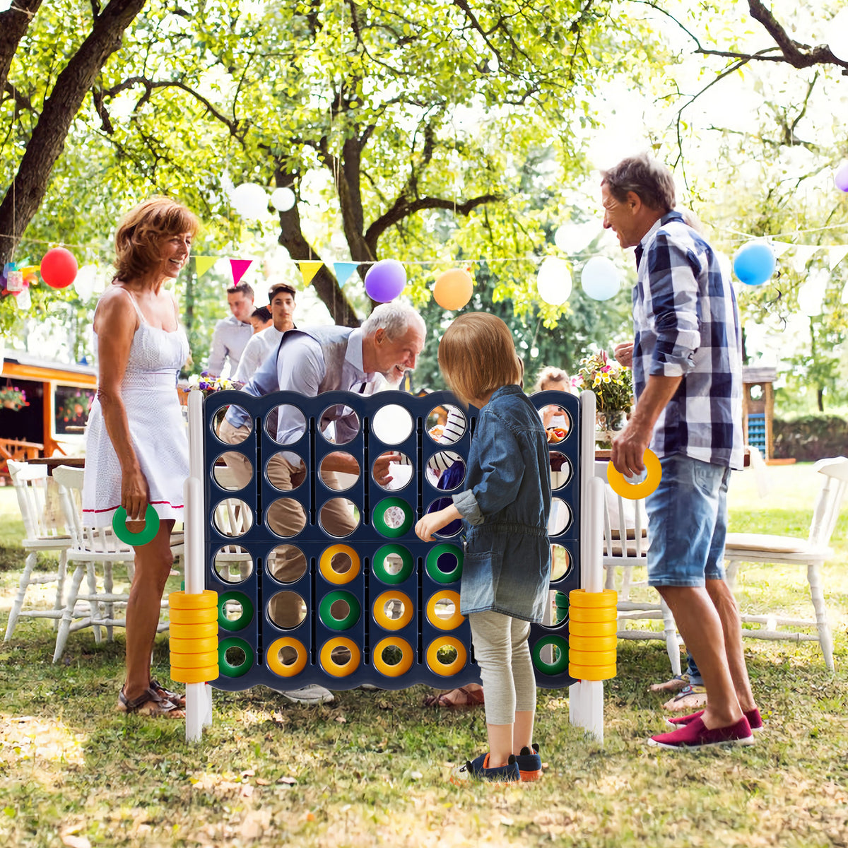 Family playing the giant four-in-a-row lawn game in a garden setting