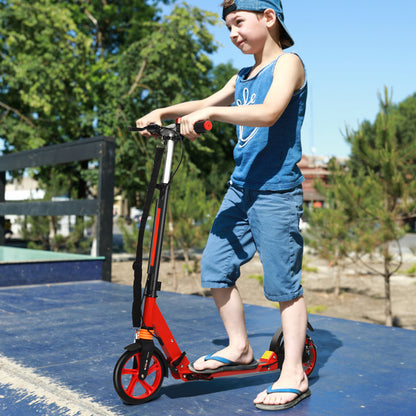 A boy rides the red kick scooter on a blue surface outdoors