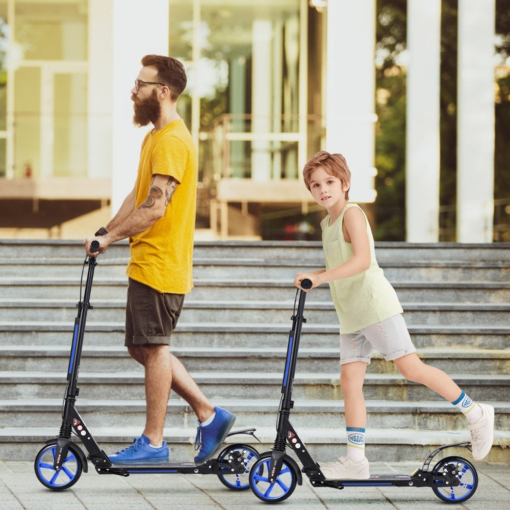 The kick scooter being ridden by a man and a boy on outdoor stairs