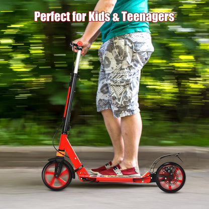 A person's legs and feet are visible as they ride the red kick scooter outdoors