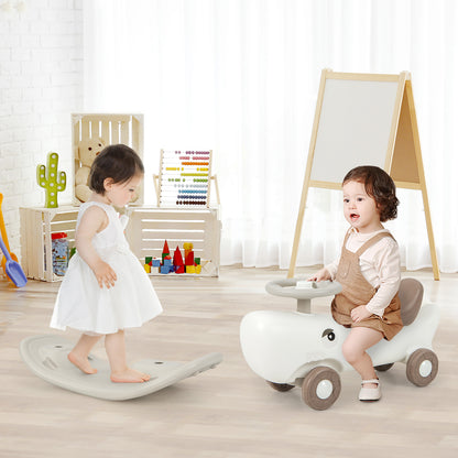 A white convertible rocking horse and sliding car with a child on it, next to a balance board in a playroom