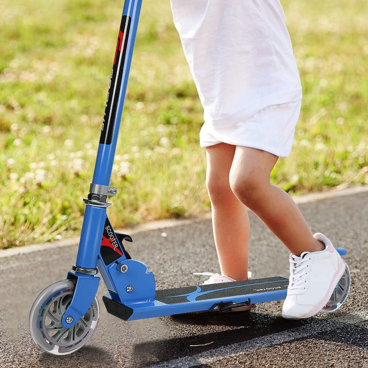 A child riding the blue stunt scooter on a paved path outdoors