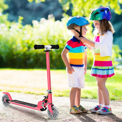 The pink stunt scooter standing on a path next to two children wearing colourful helmets