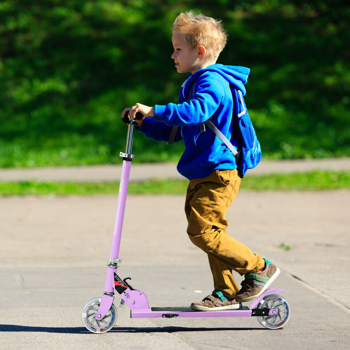 Boy riding the purple stunt scooter on a paved path