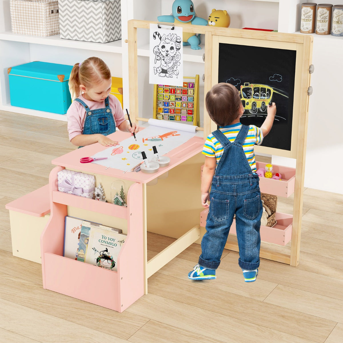 Two children using the pink kids table and chair set to draw and write