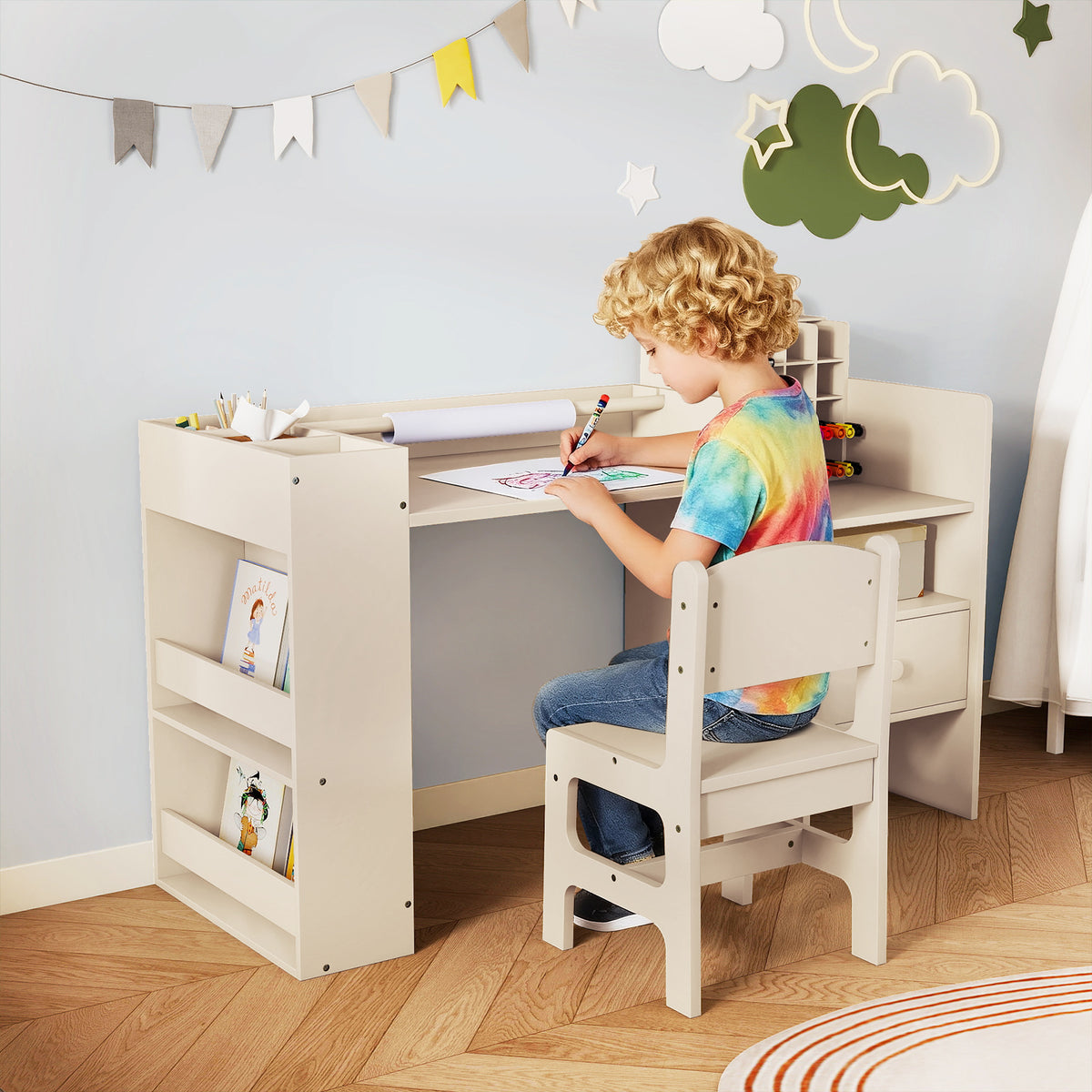 A young child sitting at the kids table and chair set drawing on paper with a felt tip pen