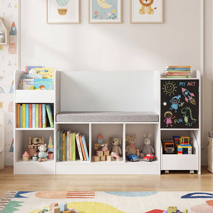The white kids storage unit is filled with books and toys on a colourful rug