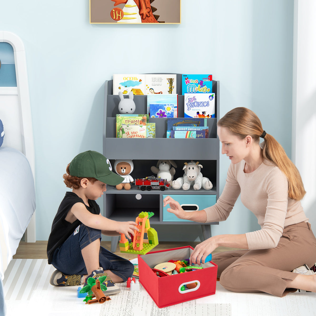 A child and an adult using the grey wooden bookshelf in a child's bedroom