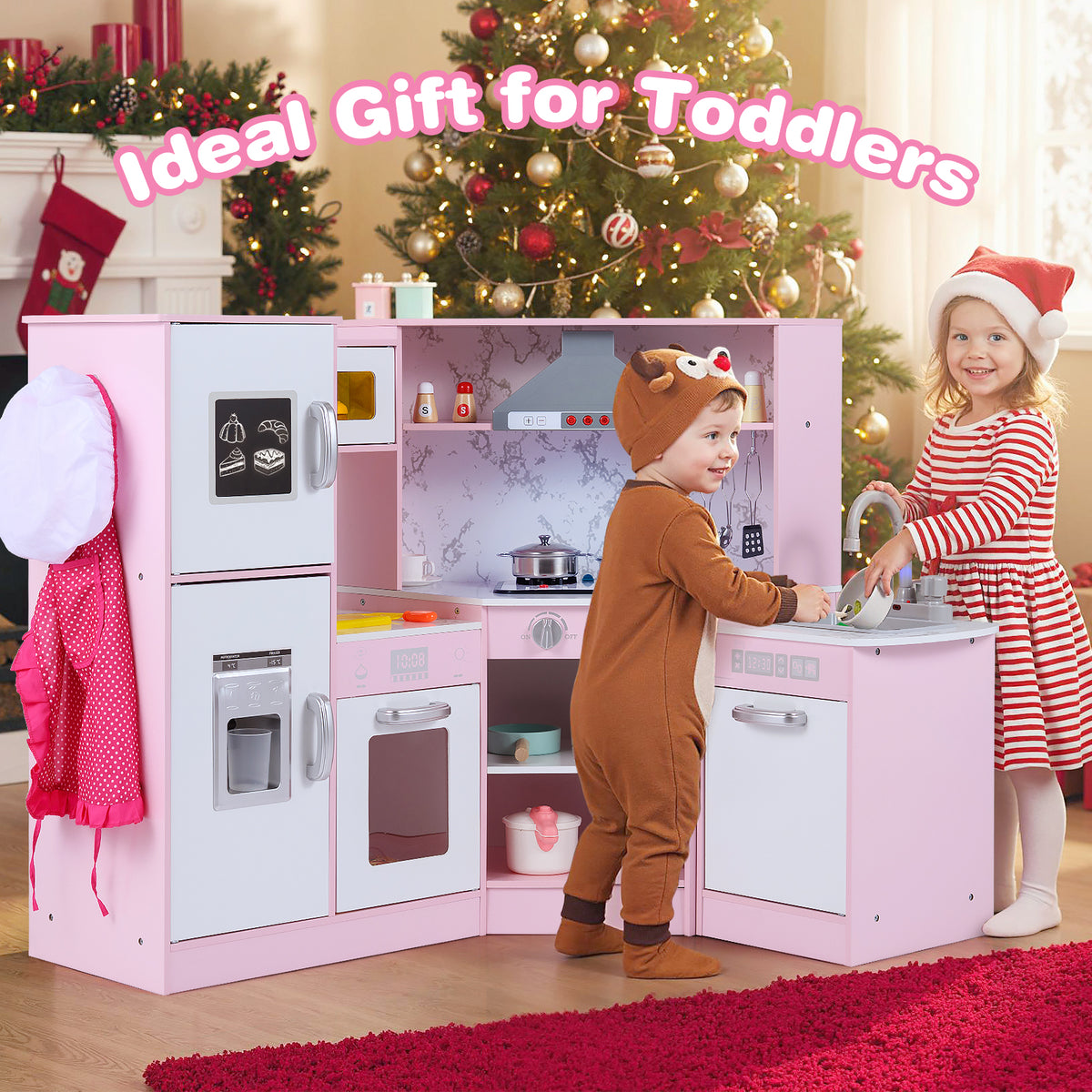 two children playing with the pink corner play kitchen in a festive room with a christmas tree