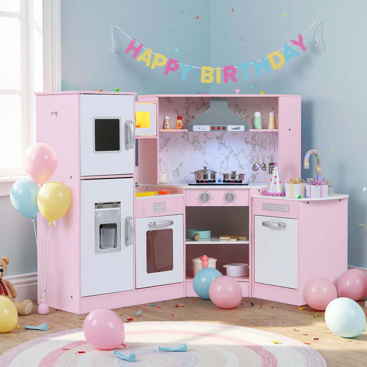 Pink corner kitchen playset set up in a room with birthday decorations and balloons