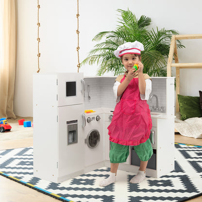 A young child wearing an apron and chef hat plays with a white play kitchen set in a room