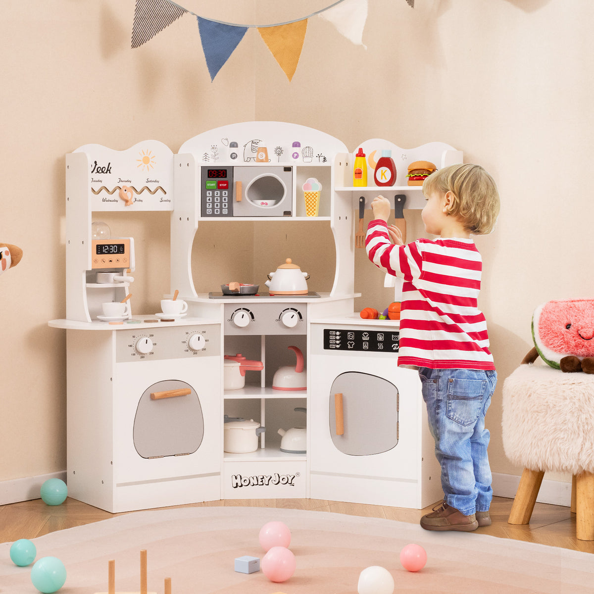 A young boy playing with the play kitchen set in a decorated nursery