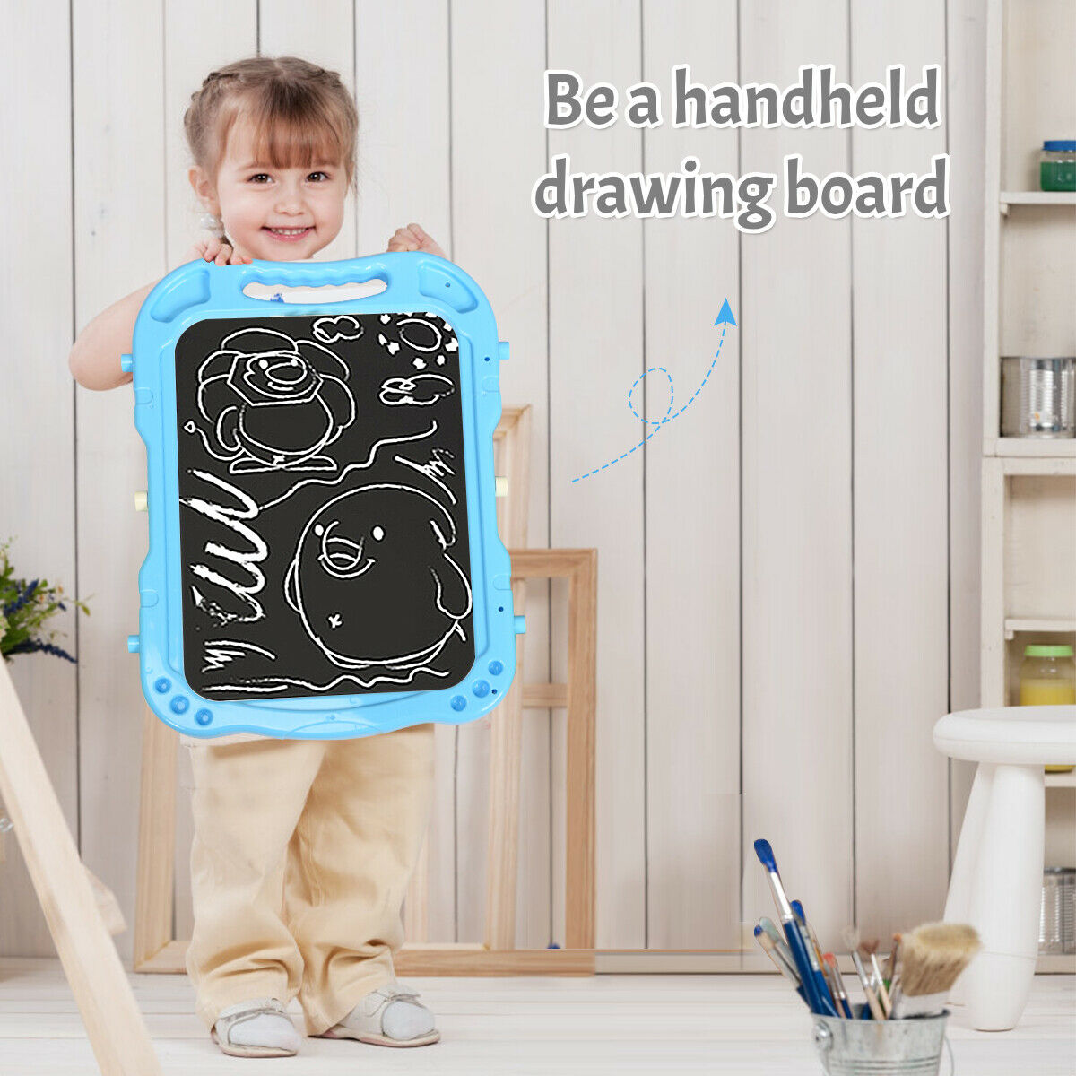 A smiling girl holds up the blue drawing board attachment
