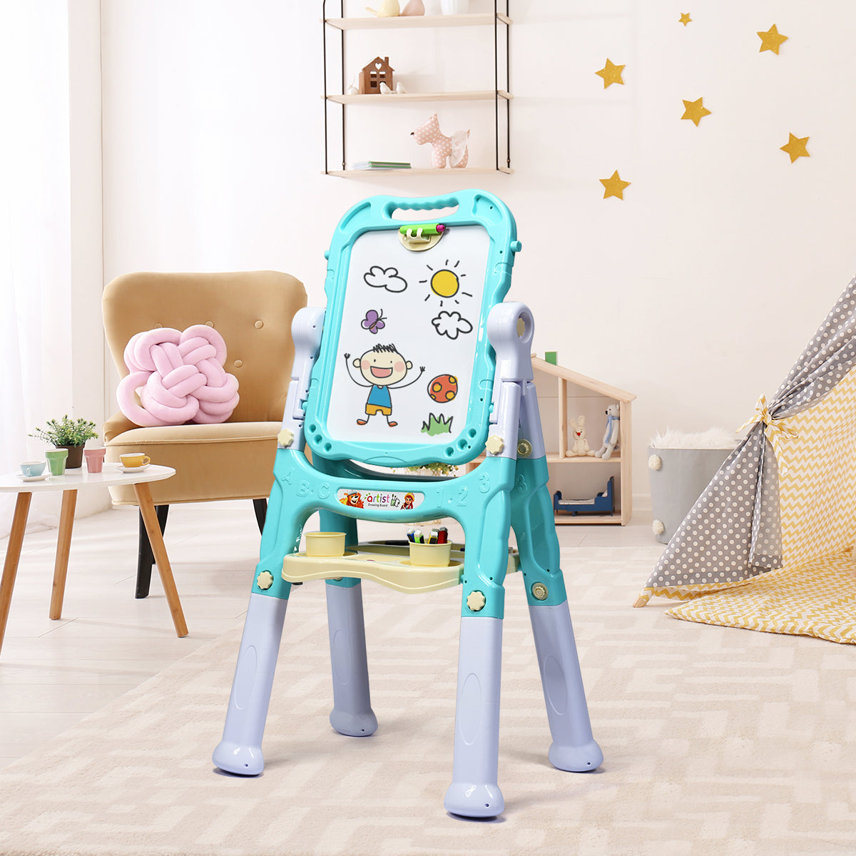 The green kids art easel is set up in a child's playroom with toys and a tent