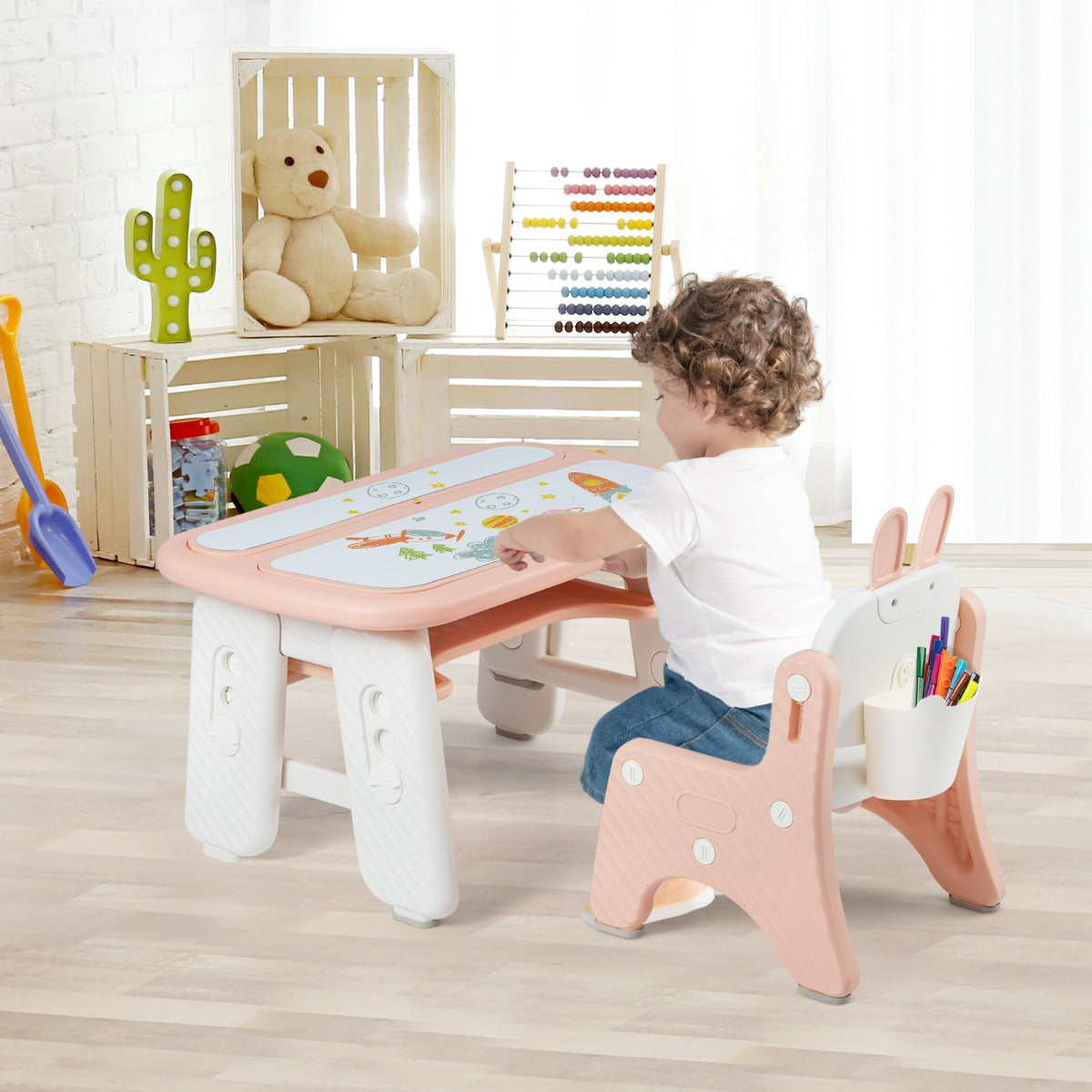 The kids table and chair set in a bright room with a child drawing on the tabletop