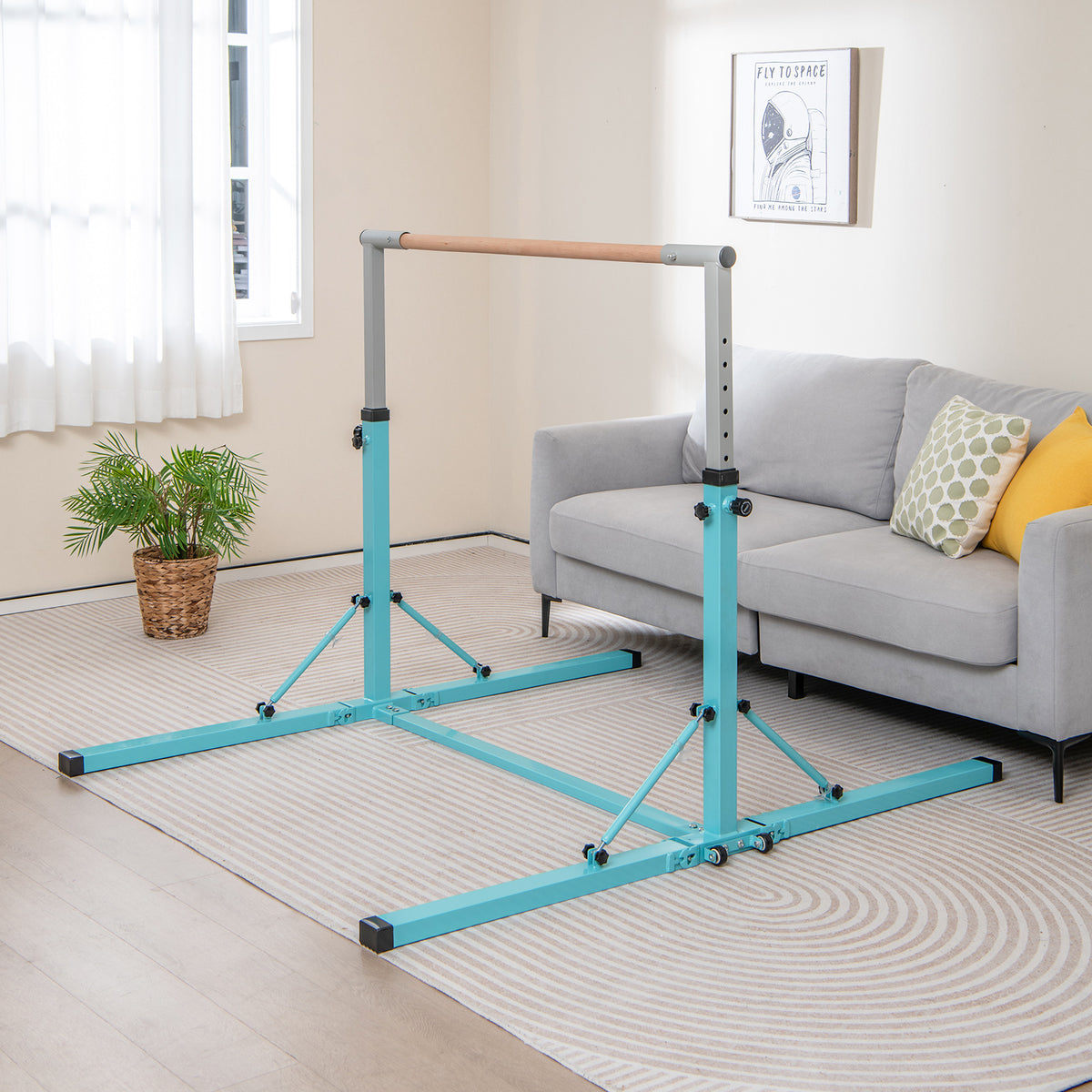 The gymnastics bar set up in a living room next to a grey sofa and a potted plant