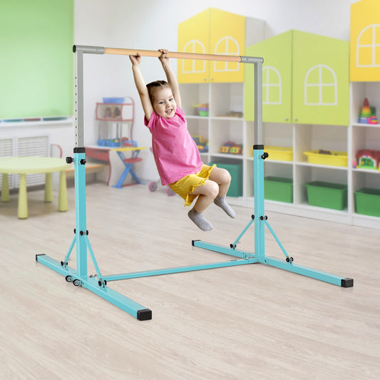 A young girl hanging from the green gymnastics bar in a colourful playroom setting