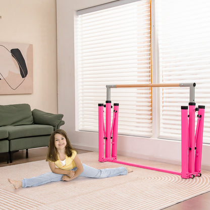 The pink gymnastics bar in a partially folded state on a patterned rug