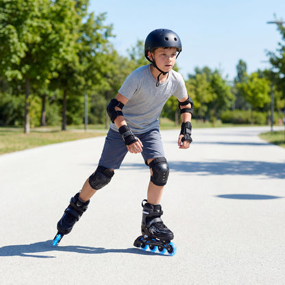 A boy wearing protective gear and the grey roller skates while skating outdoors