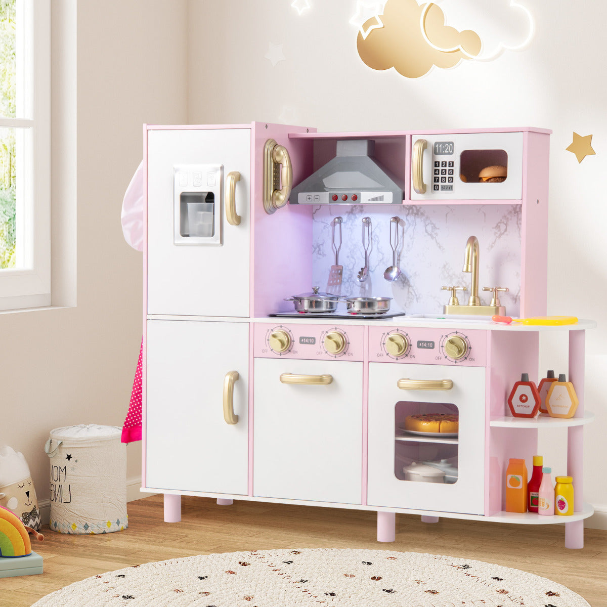 The pink wooden play kitchen set in a child's bedroom with toys