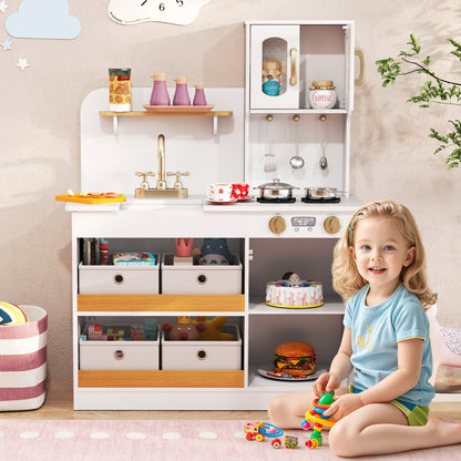 The play kitchen in a child's bedroom with a girl playing on the floor in front of it