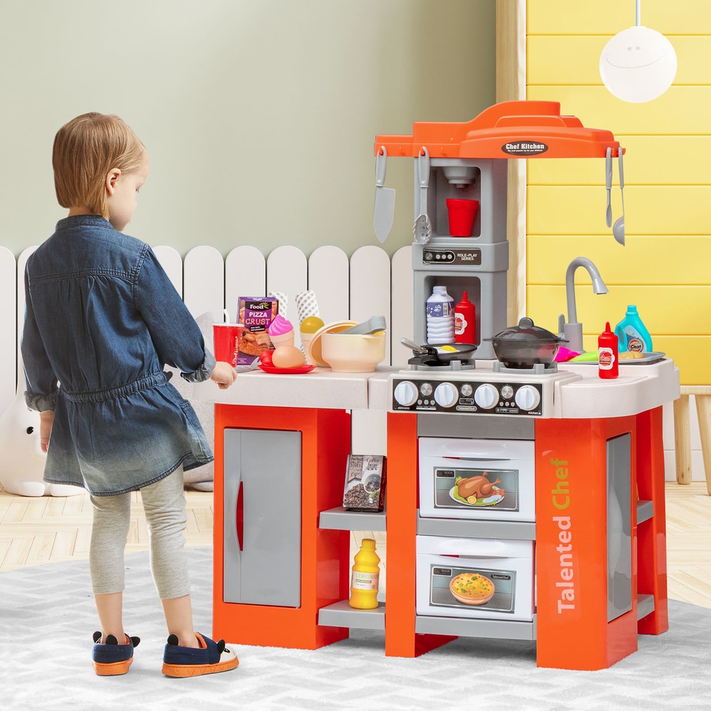 Girl playing with the orange play kitchen set in a room