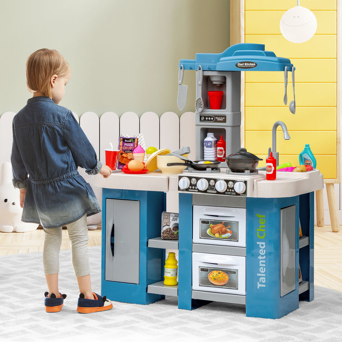 The play kitchen set standing in a playroom with a child playing with the stove